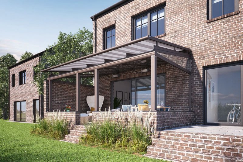 Moderne Terrasse mit Überdachung und Fenstern an einem zweigeschossigen Haus aus Backstein. Grasbewachsene Fläche im Vordergrund. Moderne Terrasse mit Überdachung und Fenstern an einem zweigeschossigen Haus aus Backstein. Grasbewachsene Fläche im Vordergrund.