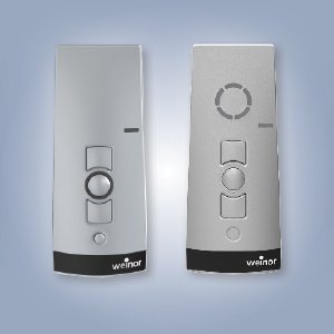 Zwei silberne Fernbedienungen mit Tasten und runden Elementen auf einem hellen Hintergrund. Zwei silberne Fernbedienungen mit Tasten und runden Elementen auf einem hellen Hintergrund.