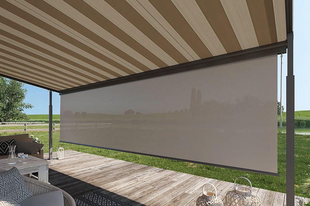 Markise mit gestreiftem Design und Terrassensituation unter einem Überdach in grüner Umgebung.
