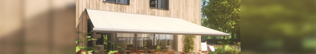 Sonnenschutz in neutralem Beige über einer Terrassensituation an einem Holzhaus.