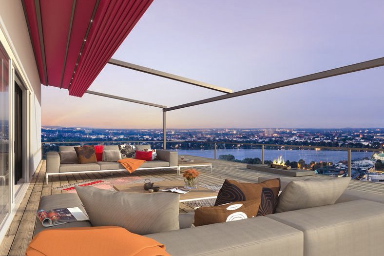 Moderne Terrassensituation mit roter Markise und Blick auf die Stadt bei Dämmerung.