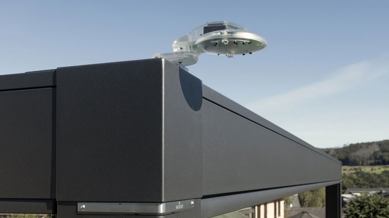 Markisenkasten in dunkler Farbe mit einer transparenten, runden Struktur oben.