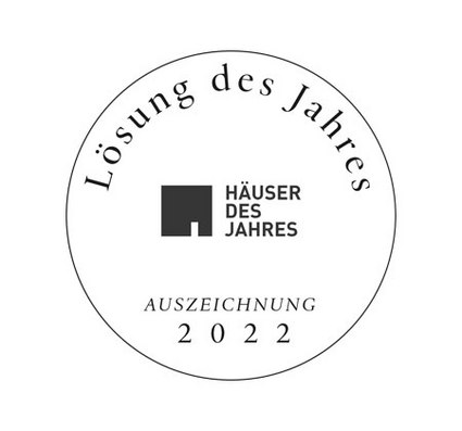Rundes Emblem mit der Aufschrift "Lösung des Jahres", darunter "Häuser des Jahres", Jahr 2022 in der Mitte.