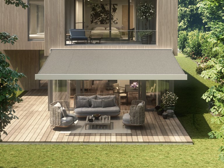 Sicht auf ein modernes Haus mit einer Überdachung und einer einladenden Terrassensituation in grüner Umgebung.