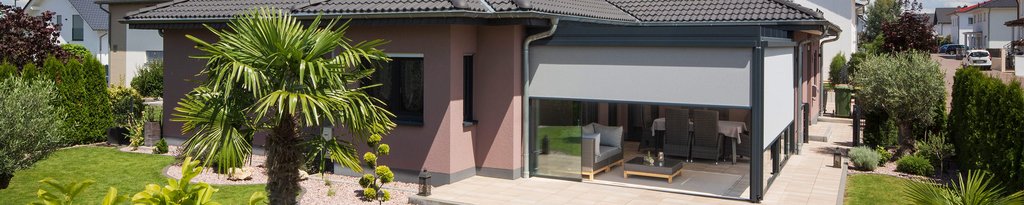 Ein modernes Haus mit einer Überdachung, umgeben von grüner Terrassensituation und Gartenanlagen. Ein modernes Haus mit einer Überdachung, umgeben von grüner Terrassensituation und Gartenanlagen.
